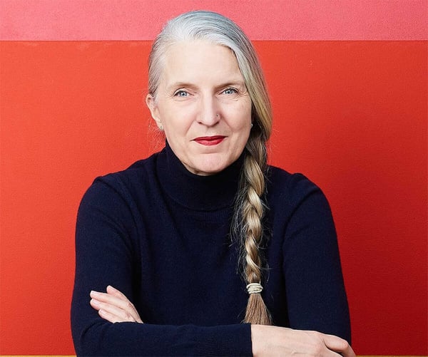 A picture of Anne Lise Kjaer, a futurist, against a red background.