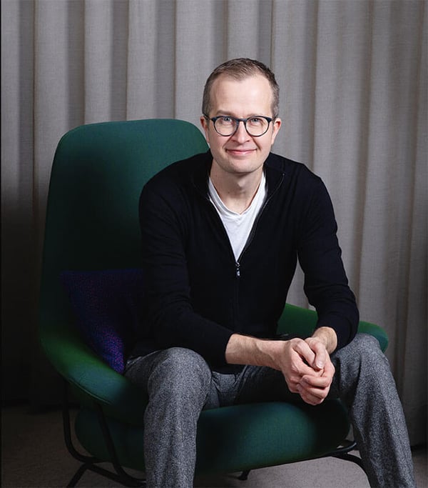 A picture of Tommi Vilkamo, Director at RELEX labs sitting on a green chair.